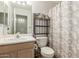 Well-lit bathroom featuring a vanity with sink and a toilet with shelving unit at 8502 W Pierson St, Phoenix, AZ 85037