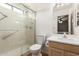 Bathroom featuring glass door shower, toilet and sink with wooden cabinets at 8502 W Pierson St, Phoenix, AZ 85037