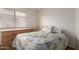 Cozy bedroom featuring a plush floral bedspread and a window with blinds at 8502 W Pierson St, Phoenix, AZ 85037