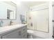 Bathroom featuring a modern vanity with grey cabinets and a shower-tub combo with sliding glass doors at 9167 N 73Rd Ln, Peoria, AZ 85345