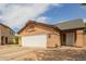 Tan single Gathering house with a white door and white garage door at 9167 N 73Rd Ln, Peoria, AZ 85345