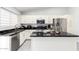 Kitchen features white cabinets, black countertops, stainless steel appliances, and a center island at 9167 N 73Rd Ln, Peoria, AZ 85345