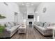 Living room featuring a fireplace, high ceilings, wood floors, and neutral colored furniture at 9167 N 73Rd Ln, Peoria, AZ 85345