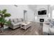 Bright living room with high ceilings, fireplace, wood floors and neutral colored furniture at 9167 N 73Rd Ln, Peoria, AZ 85345