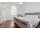 Bright main bedroom boasts a plush bed, hardwood floors, and ensuite bathroom access at 9167 N 73Rd Ln, Peoria, AZ 85345