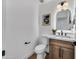 Half bath features wood vanity, modern light fixture, decorative mirror, and toilet at 920 E Leslie E Ave, San Tan Valley, AZ 85140