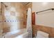 This tiled bathroom includes a tub with shower, tiled shower caddy, and updated lighting at 9451 E Becker Ln # 2004, Scottsdale, AZ 85260