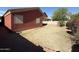 View of the backyard featuring a red-toned exterior wall with limited grass coverage at 10247 W Hilton Ave, Tolleson, AZ 85353
