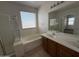 Well lit bathroom features a soaking tub, shower, a vanity with dual sinks and wood cabinets at 10247 W Hilton Ave, Tolleson, AZ 85353
