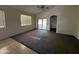 Bright living room with carpet and tile floors features a ceiling fan and sliding glass door at 10247 W Hilton Ave, Tolleson, AZ 85353