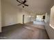 Open-concept living room with ceiling fan flows into kitchen with tile floor and breakfast bar at 10247 W Hilton Ave, Tolleson, AZ 85353