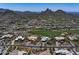 An aerial view features a desert community with a golf course and mountain views at 10283 E Running Deer Trl, Scottsdale, AZ 85262