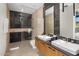 Modern bathroom with black marble tile accents, dual sinks, and walk-in shower at 10283 E Running Deer Trl, Scottsdale, AZ 85262