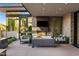 Inviting outdoor fireplace and TV area with comfortable seating, perfect for relaxing and entertaining outdoors at 10283 E Running Deer Trl, Scottsdale, AZ 85262