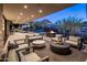 Spacious outdoor living area with comfortable seating, a modern fireplace, and beautiful desert views at twilight at 10283 E Running Deer Trl, Scottsdale, AZ 85262