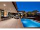 An outdoor kitchen and swim-up bar adjoin a sparkling pool with a spa in this luxury outdoor living space at 10283 E Running Deer Trl, Scottsdale, AZ 85262