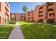Beautifully landscaped courtyard with lush green grass surrounded by charming multi-story condominium buildings at 12222 N Paradise Vlg S Pkwy # 237, Phoenix, AZ 85032
