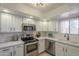 Well-equipped kitchen featuring stainless steel appliances, white cabinets, and modern fixtures at 12222 N Paradise Vlg S Pkwy # 237, Phoenix, AZ 85032