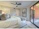 Neutral main bedroom featuring a ceiling fan, king bed, neutral paint, and a sliding door to patio at 12222 N Paradise Vlg S Pkwy # 237, Phoenix, AZ 85032