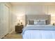 Stylish main bedroom featuring a white paneled accent wall, king bed, and a bedside table at 12222 N Paradise Vlg S Pkwy # 237, Phoenix, AZ 85032