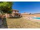Expansive backyard with covered patio extends from a two-story home with desert landscaping at 12571 W Clarendon Ave, Avondale, AZ 85392