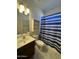 Bathroom with a single vanity, toilet, and a shower/tub combo with a striped curtain at 12571 W Clarendon Ave, Avondale, AZ 85392