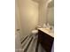 Well-lit half-bathroom featuring a single vanity, commode, and tile flooring at 12571 W Clarendon Ave, Avondale, AZ 85392