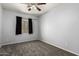 Bedroom featuring light gray walls, carpet, a window, and a fan at 12571 W Clarendon Ave, Avondale, AZ 85392