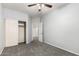 Carpeted bedroom with closet and fan, and doorway leading to hall at 12571 W Clarendon Ave, Avondale, AZ 85392