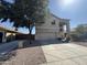 Two story home with neutral colored paint, a two car garage, mature landscaping, and an expansive driveway at 12571 W Clarendon Ave, Avondale, AZ 85392