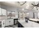 Sunlit kitchen boasts white cabinets, stainless steel appliances, backyard view, and an island with a waterfall countertop at 12571 W Clarendon Ave, Avondale, AZ 85392