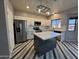 Beautiful kitchen featuring white cabinets, stainless steel appliances, a marble island, and stylish flooring at 12571 W Clarendon Ave, Avondale, AZ 85392