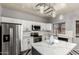 Bright kitchen features white cabinets, stainless steel appliances, and a waterfall island with statement light fixture at 12571 W Clarendon Ave, Avondale, AZ 85392