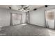 Large living room with gray carpet, ceiling fan, and abundant natural light at 12571 W Clarendon Ave, Avondale, AZ 85392