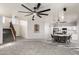 Open floorplan with carpeted living area, dining space, and kitchen with white cabinets at 12571 W Clarendon Ave, Avondale, AZ 85392