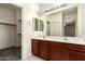 The main bath features double sinks, warm colored vanity, and a linen closet at 12571 W Clarendon Ave, Avondale, AZ 85392
