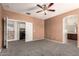 Main bedroom with walk-in closet/laundry area and ensuite bathroom, featuring cozy carpet and a ceiling fan at 12571 W Clarendon Ave, Avondale, AZ 85392