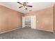 Carpeted main bedroom featuring a ceiling fan and an entry to the upper level of the home at 12571 W Clarendon Ave, Avondale, AZ 85392
