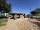 Open air community pavilion with picnic table surrounded by green lawns on a bright sunny day at 12571 W Clarendon Ave, Avondale, AZ 85392