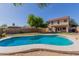 Backyard with lush green grass, sparkling blue pool, and well-manicured landscaping create a relaxing oasis at 12571 W Clarendon Ave, Avondale, AZ 85392