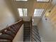Stairway with wood railing leading to the upper level and windows providing natural light at 12571 W Clarendon Ave, Avondale, AZ 85392