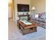 Cozy living room featuring floral sofa, tile flooring and a large flat screen TV at 1384 E Las Colinas Dr, Chandler, AZ 85249
