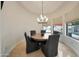 Bright dining room featuring a modern chandelier, round table and views of outdoor patio at 1423 E Beverly Ln, Phoenix, AZ 85022