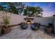 Outdoor fireplace area featuring comfortable seating, a stone fireplace, and lush landscaping at 1423 E Beverly Ln, Phoenix, AZ 85022