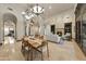 Inviting dining and living area featuring travertine floors, a fireplace, and arched entryways at 1423 E Beverly Ln, Phoenix, AZ 85022