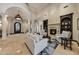 Elegant living room featuring travertine flooring, a fireplace, arched entryways, and natural light at 1423 E Beverly Ln, Phoenix, AZ 85022