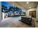Covered patio featuring comfortable seating, travertine flooring, and views of the beautifully landscaped backyard at 1423 E Beverly Ln, Phoenix, AZ 85022