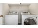 This laundry room features a white washer and dryer with built in shelving at 16112 W Buchanan St, Goodyear, AZ 85338