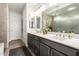 Elegant bathroom with dual sinks, vanity with storage, and a glass-enclosed shower stall at 16906 W Palm Ln, Goodyear, AZ 85395