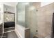 Clean bathroom with a glass enclosed shower, dark vanity with storage, and decorative tiling at 16906 W Palm Ln, Goodyear, AZ 85395